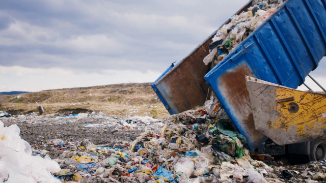 Dump Truck Unloading Waste On Landfill